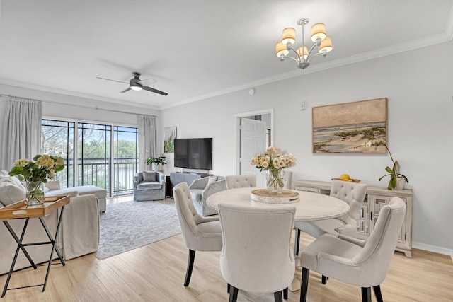 dining area featuring ceiling fan with notable chandelier, light wood-type flooring, baseboards, and crown molding