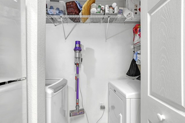 clothes washing area featuring laundry area and washer and clothes dryer