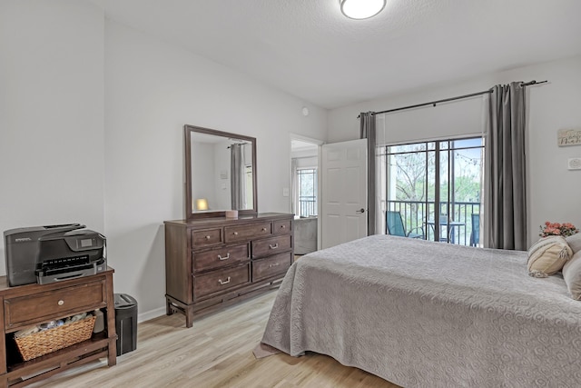 bedroom featuring baseboards, light wood-style floors, and access to exterior