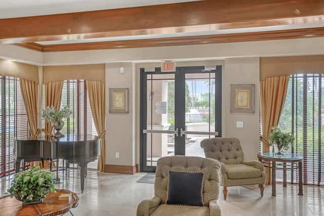 sitting room featuring beamed ceiling, baseboards, and tile patterned floors