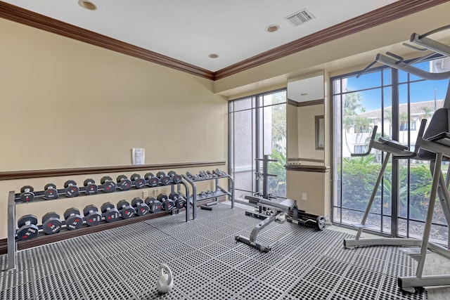 gym with ornamental molding, carpet flooring, visible vents, and baseboards