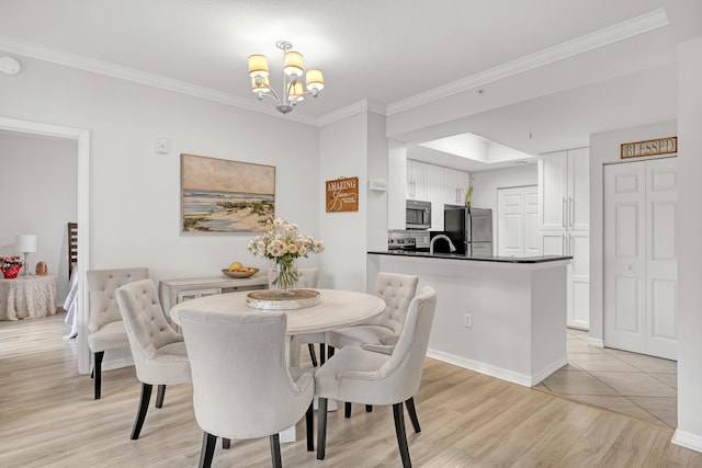 dining area featuring an inviting chandelier, baseboards, ornamental molding, and light wood finished floors