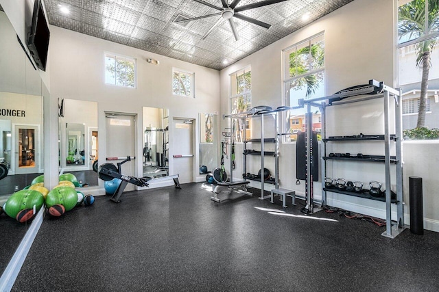 gym featuring a ceiling fan and baseboards