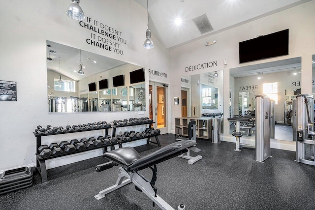 workout area featuring high vaulted ceiling, visible vents, and a healthy amount of sunlight