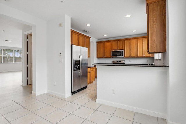 kitchen featuring dark countertops, light tile patterned floors, visible vents, and appliances with stainless steel finishes