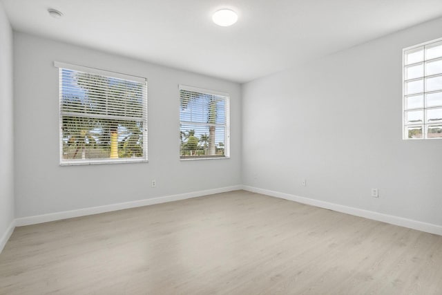 empty room with light wood-type flooring and baseboards