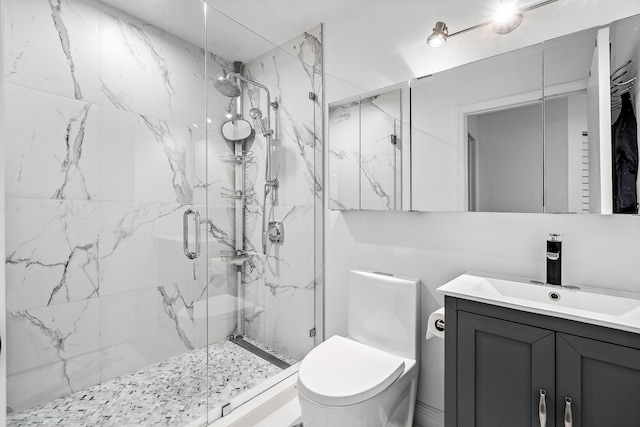 full bath with toilet, a marble finish shower, and vanity