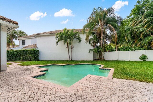 view of swimming pool featuring a patio area, a fenced backyard, a fenced in pool, and a lawn