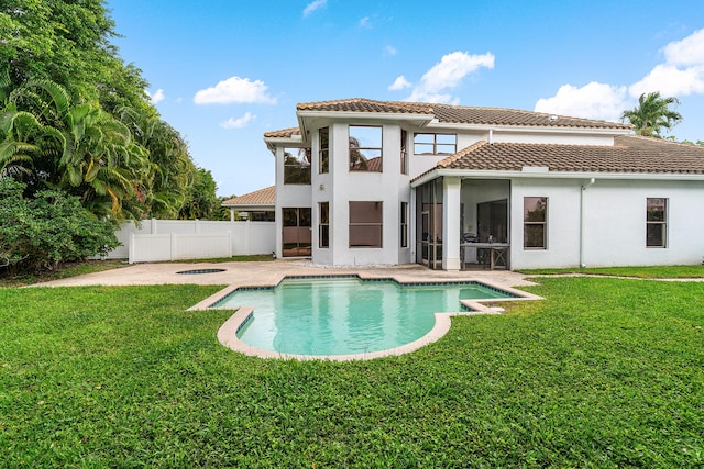 rear view of house featuring a tiled roof, fence, a lawn, and a patio