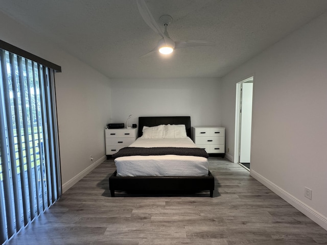 bedroom with ceiling fan, baseboards, and wood finished floors