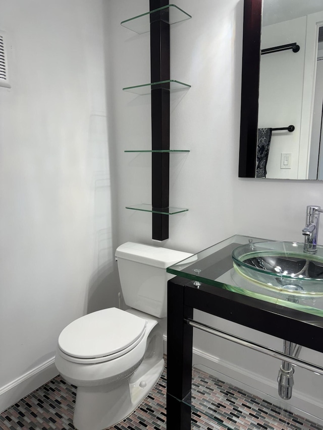 bathroom with tile patterned flooring, vanity, toilet, and baseboards