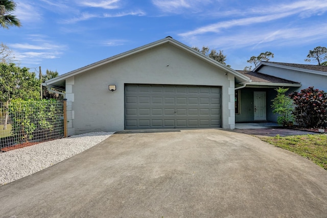 ranch-style home featuring a garage, driveway, and stucco siding