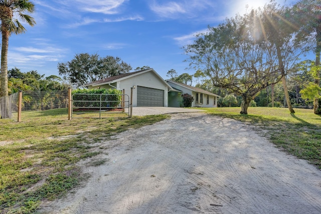 view of front of property with a garage, a front yard, driveway, and fence