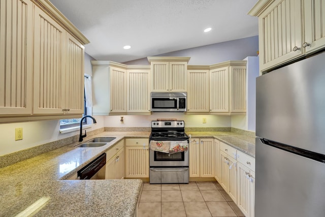 kitchen featuring light tile patterned floors, recessed lighting, stainless steel appliances, a sink, and cream cabinetry