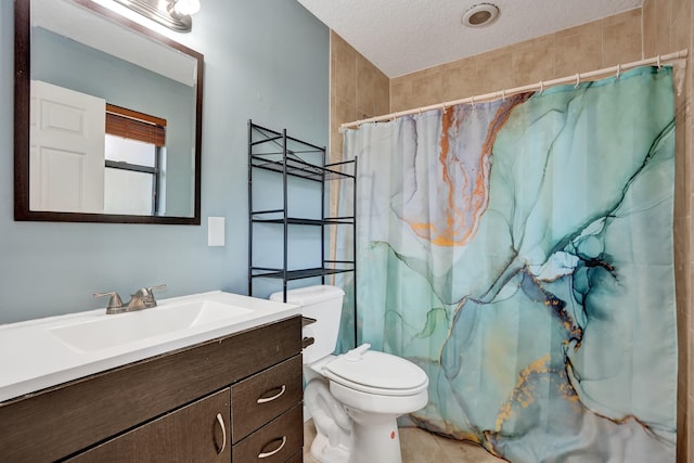 full bathroom featuring a shower with curtain, vanity, toilet, and a textured ceiling