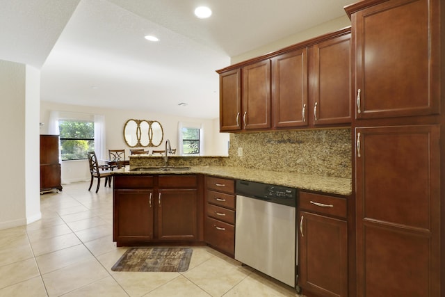 kitchen featuring light stone counters, tasteful backsplash, a sink, dishwasher, and a peninsula