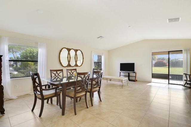 dining area featuring vaulted ceiling, light tile patterned floors, visible vents, and a wealth of natural light