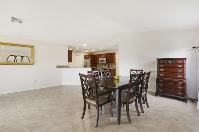 dining area featuring light tile patterned floors, lofted ceiling, recessed lighting, visible vents, and baseboards