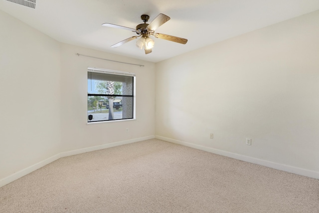 carpeted empty room featuring a ceiling fan, visible vents, and baseboards