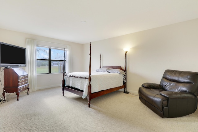 bedroom with baseboards and light colored carpet