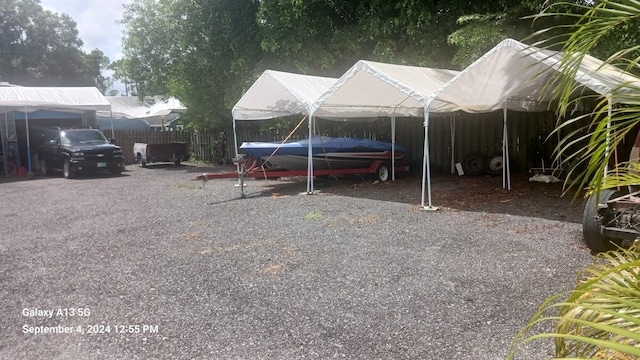 view of parking featuring a carport and fence