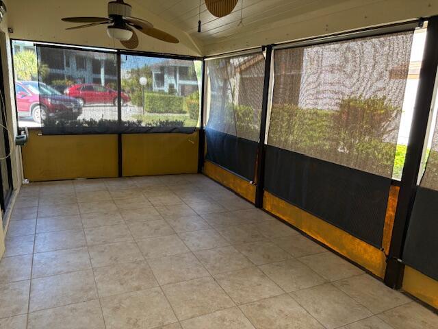 unfurnished sunroom featuring vaulted ceiling and a ceiling fan