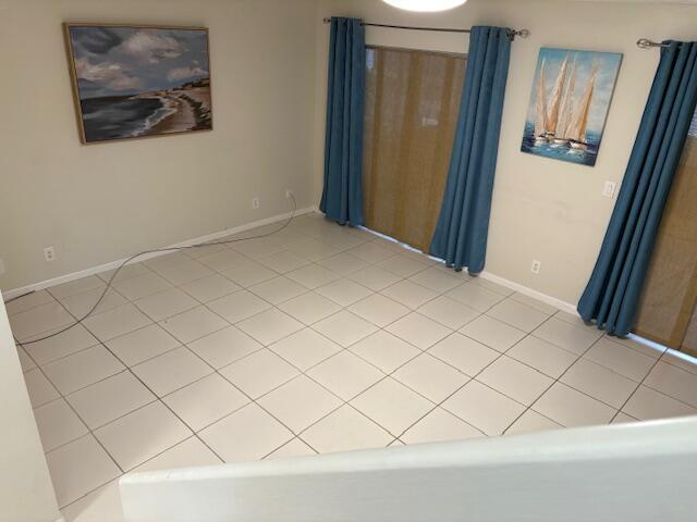 unfurnished room with light tile patterned floors and baseboards