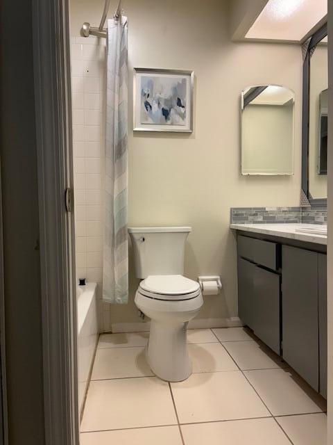 full bath featuring tile patterned floors, toilet, vanity, and shower / tub combo