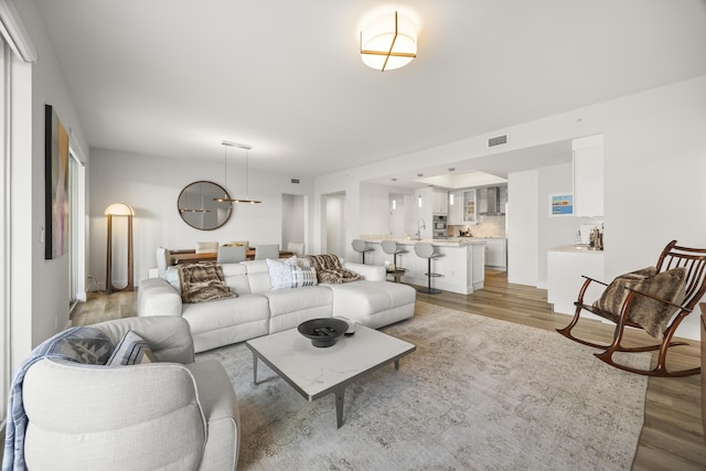 living room featuring light wood-style floors and visible vents