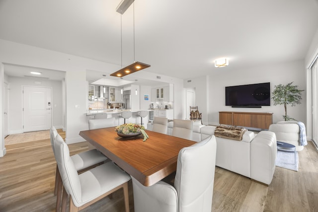 dining room with baseboards and light wood-style floors