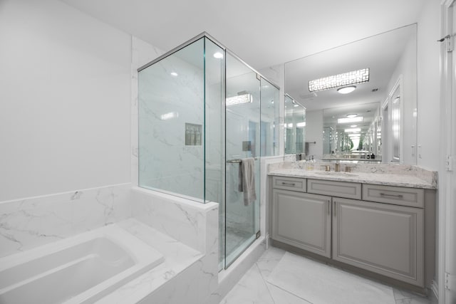 full bathroom with a garden tub, marble finish floor, a marble finish shower, and vanity