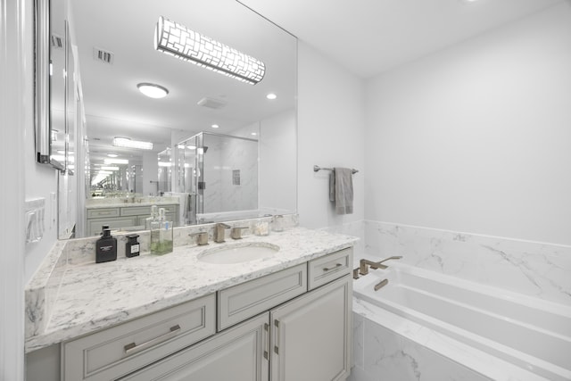 full bath featuring visible vents, a garden tub, vanity, and a marble finish shower