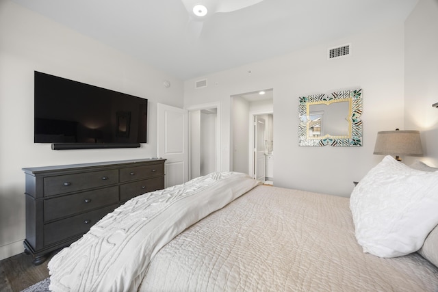 bedroom with visible vents, baseboards, and wood finished floors