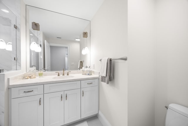 bathroom featuring baseboards, a shower stall, toilet, and vanity