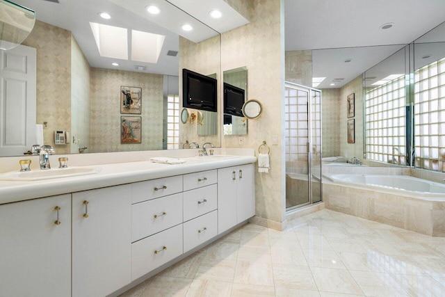 bathroom with a garden tub, double vanity, a stall shower, and a sink