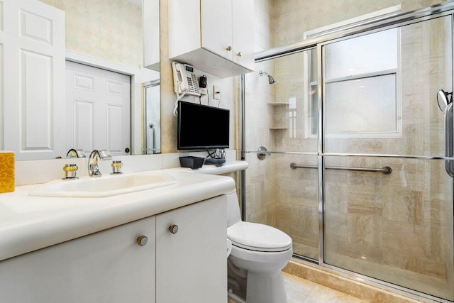 bathroom featuring toilet, a stall shower, and vanity