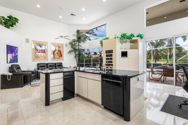 kitchen featuring black dishwasher, dark countertops, visible vents, a high ceiling, and open floor plan