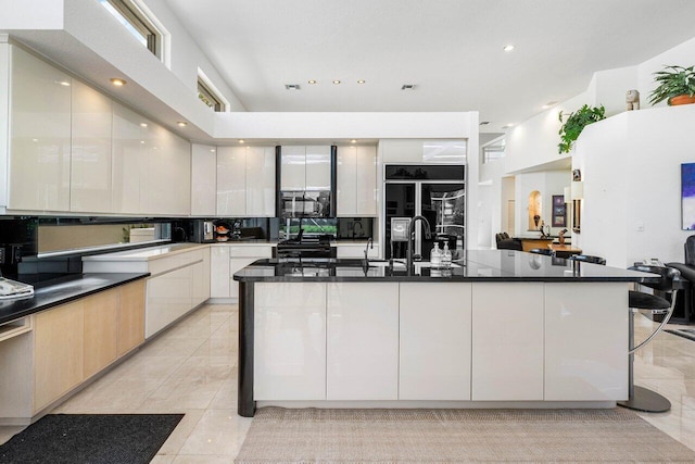 kitchen featuring black microwave, modern cabinets, dark countertops, and range