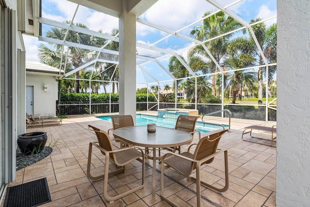 view of patio / terrace featuring glass enclosure, a pool with connected hot tub, and visible vents