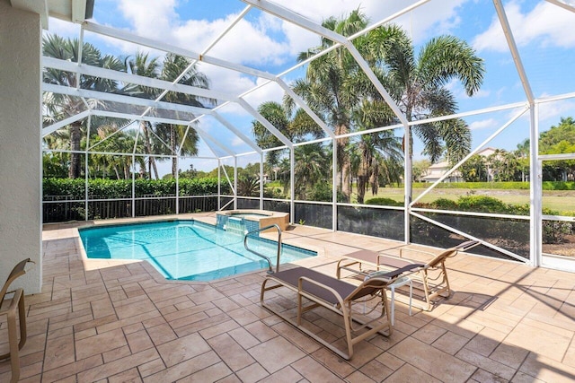 view of pool featuring a pool with connected hot tub, glass enclosure, and a patio