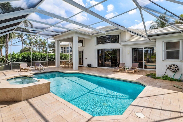 view of swimming pool featuring a pool with connected hot tub, glass enclosure, and a patio