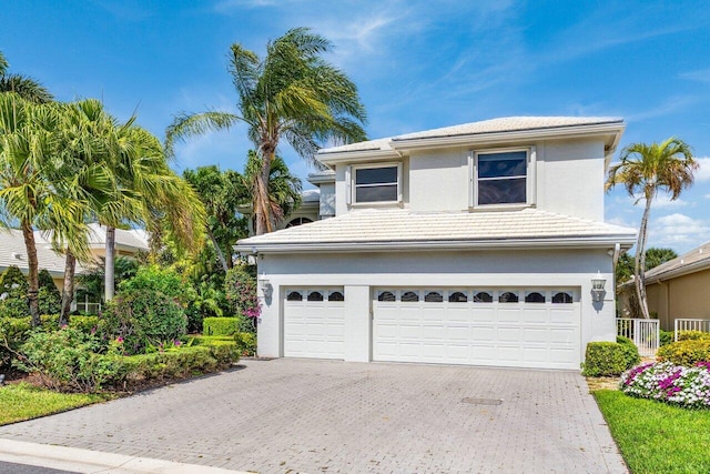 view of front of property with a tiled roof, decorative driveway, and stucco siding