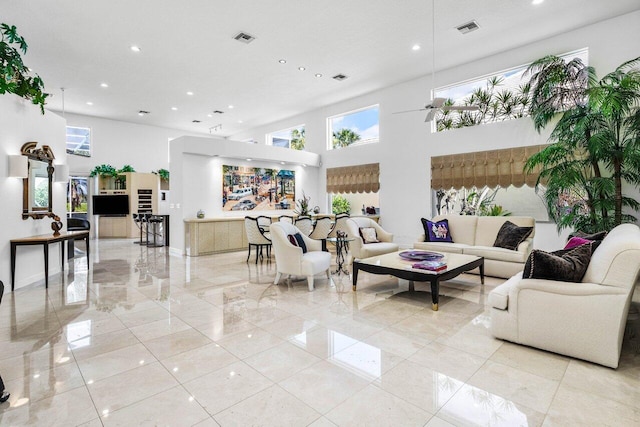 living room with a high ceiling, visible vents, and recessed lighting