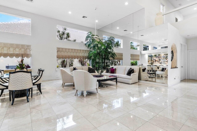 living area featuring a high ceiling and recessed lighting