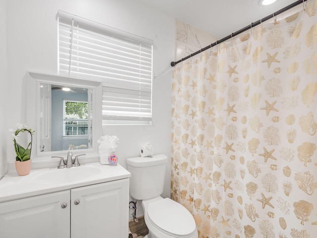 bathroom with a shower with shower curtain, vanity, and toilet