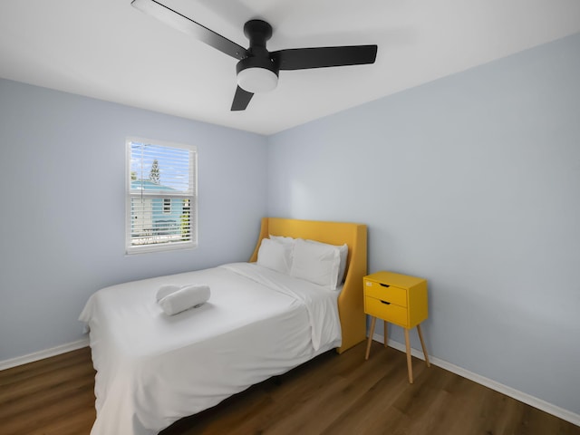 bedroom with ceiling fan, baseboards, and wood finished floors