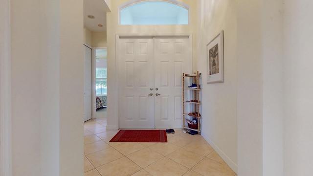 entryway with baseboards and light tile patterned floors