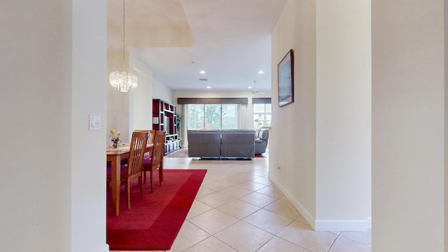 hallway featuring recessed lighting, light tile patterned flooring, baseboards, and an inviting chandelier