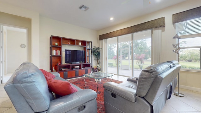 living room featuring plenty of natural light, visible vents, baseboards, and light tile patterned flooring