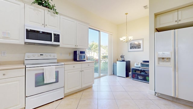 kitchen with light tile patterned floors, white appliances, visible vents, white cabinets, and light countertops